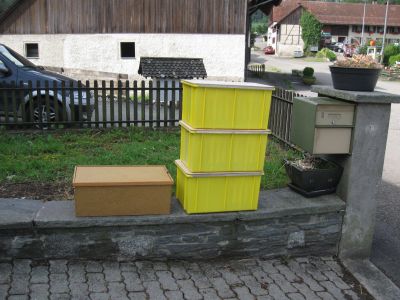 Bienenwaben in Behältnissen vor dem Haus bereit um mitgenommen zu werden